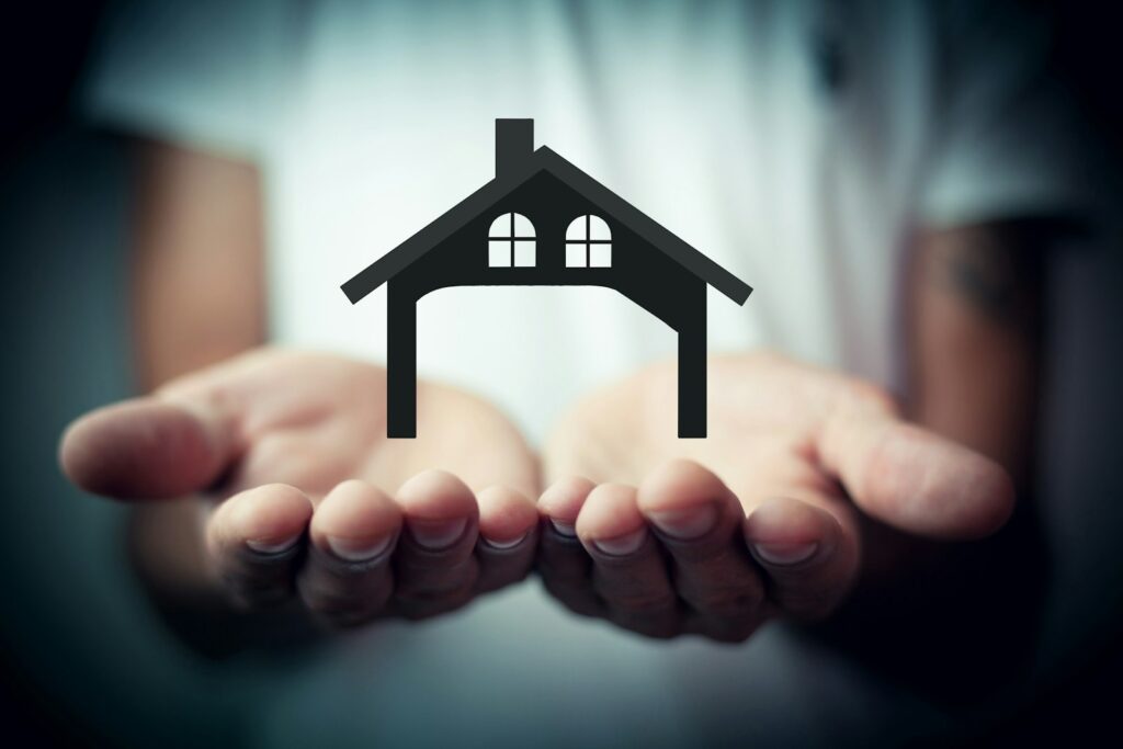 Hands holding a silhouette of a house